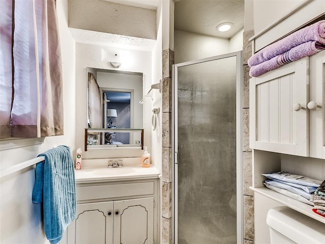 bathroom featuring toilet, walk in shower, and vanity