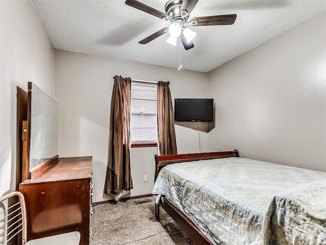 bedroom featuring ceiling fan, a textured ceiling, and light carpet