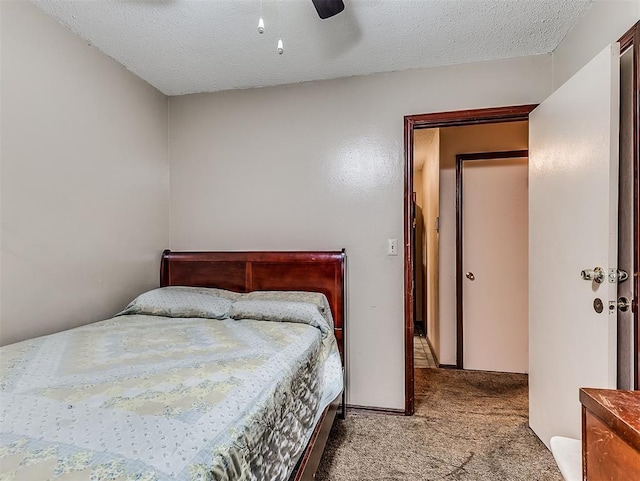 carpeted bedroom featuring ceiling fan and a textured ceiling