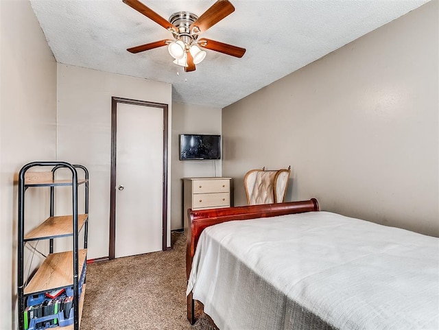 bedroom with ceiling fan, carpet, and a textured ceiling