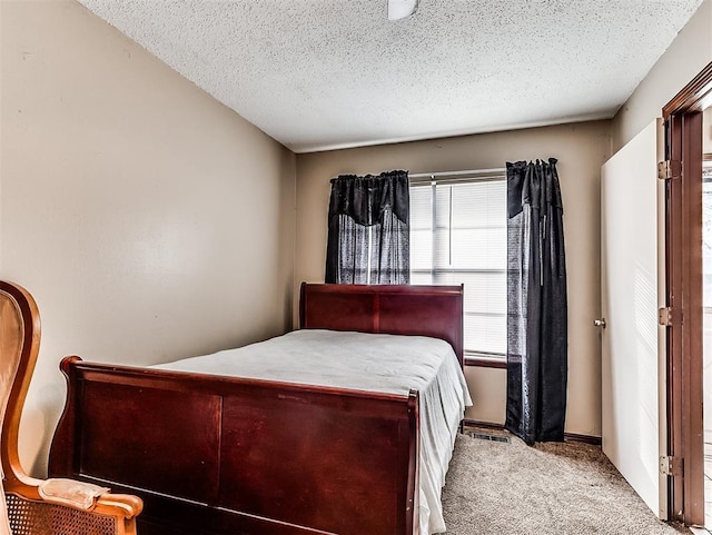 bedroom featuring light carpet and a textured ceiling