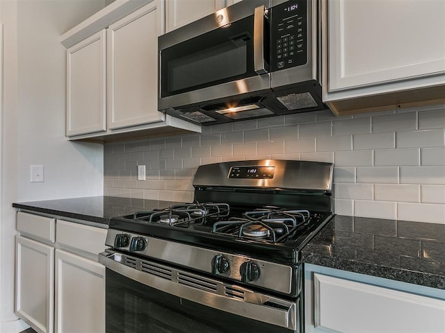 13156 Mannington Rd, Edmond, OK 73025 - kitchen with stainless steel appliances, decorative backsplash, white cabinets, and dark stone counters