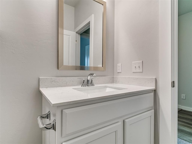 13156 Mannington Rd, Edmond, OK 73025 - bathroom with vanity, wood finished floors, and a textured wall