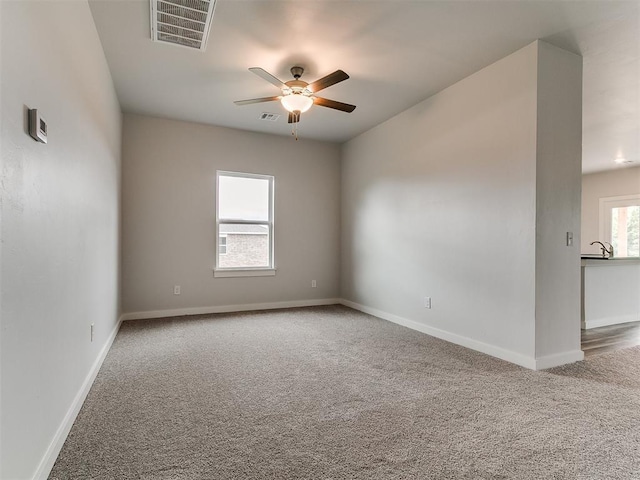 13156 Mannington Rd, Edmond, OK 73025 - spare room featuring carpet, a ceiling fan, baseboards, and a sink