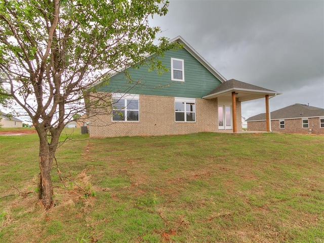 13156 Mannington Rd, Edmond, OK 73025 - rear view of property featuring a lawn and brick siding