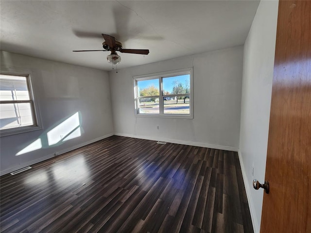 spare room featuring dark wood-type flooring and ceiling fan