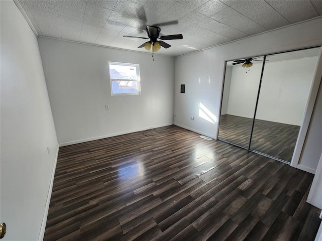 unfurnished bedroom featuring dark hardwood / wood-style flooring, a closet, and ceiling fan