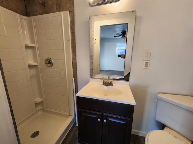 bathroom featuring ceiling fan, walk in shower, vanity, and toilet