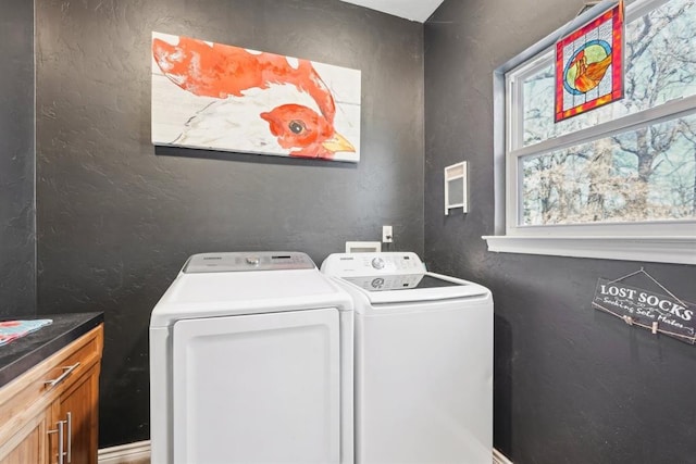 clothes washing area with cabinets and independent washer and dryer