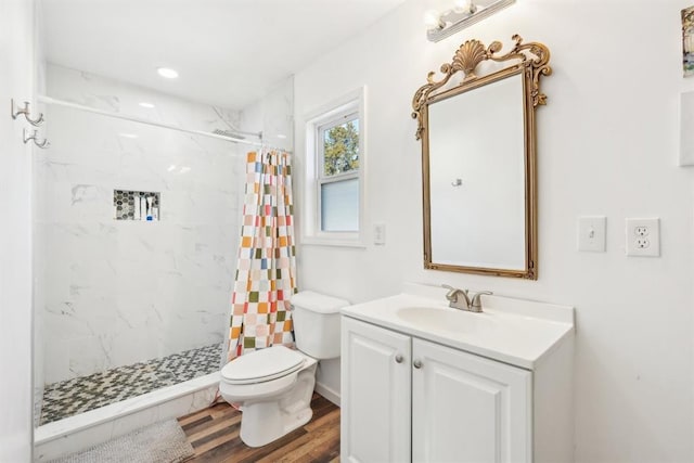 bathroom featuring wood-type flooring, toilet, walk in shower, and vanity