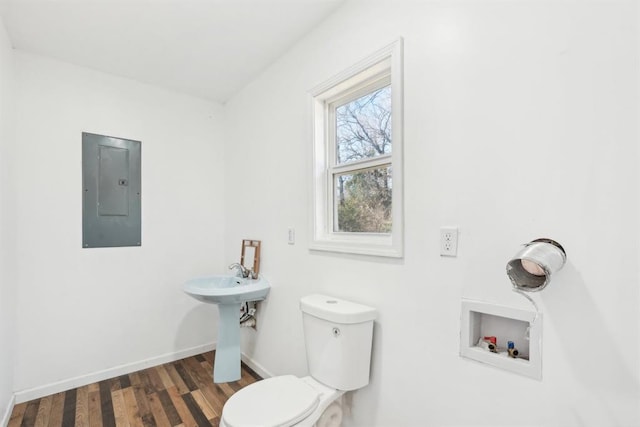 bathroom with sink, hardwood / wood-style floors, electric panel, and toilet