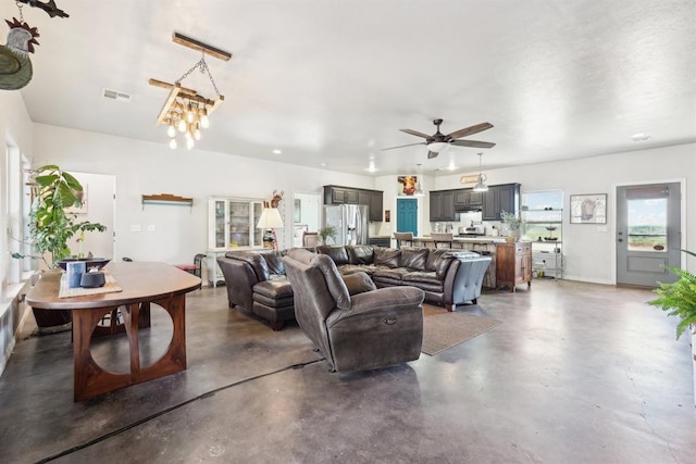 living room with finished concrete flooring, visible vents, and a ceiling fan