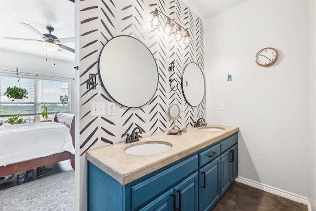 bathroom featuring ceiling fan, a sink, baseboards, and double vanity