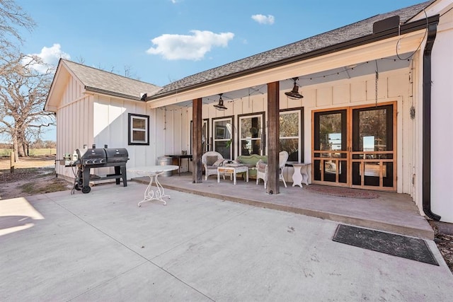 rear view of property with board and batten siding and a patio area