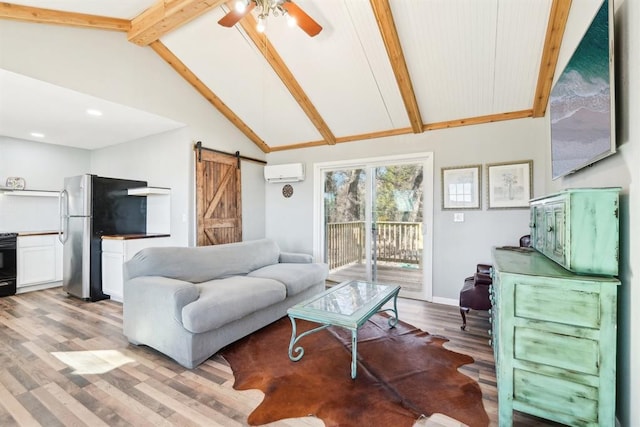 living room with beam ceiling, light wood-style flooring, a wall mounted AC, a barn door, and ceiling fan