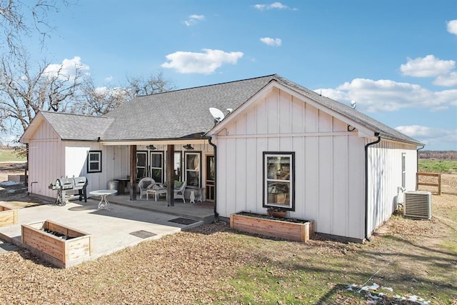 back of house with a patio, a shingled roof, central AC, and board and batten siding