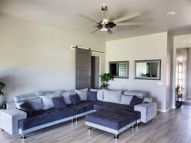 living room with ceiling fan and a barn door