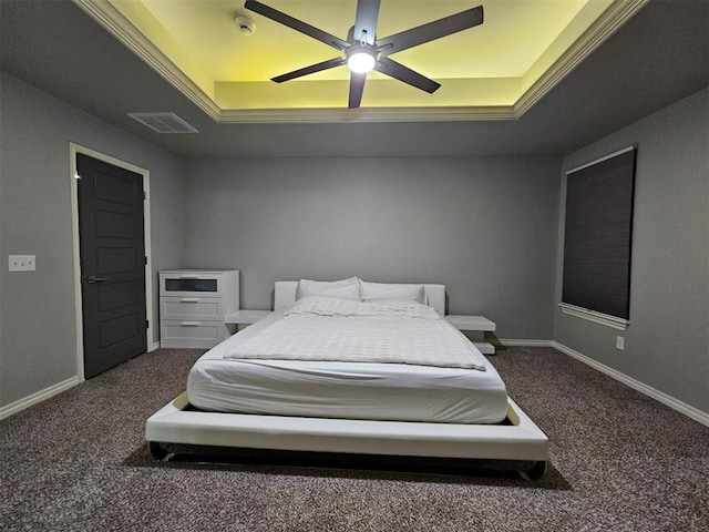 carpeted bedroom with ceiling fan and a raised ceiling