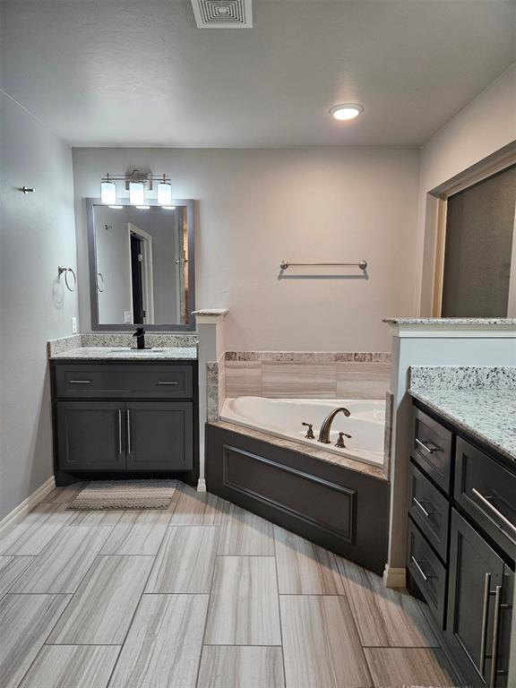 bathroom with a bath and vanity