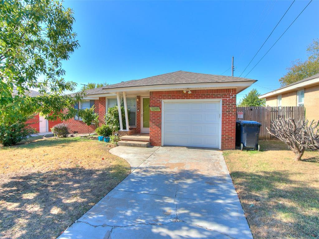 ranch-style home with a front lawn and a garage