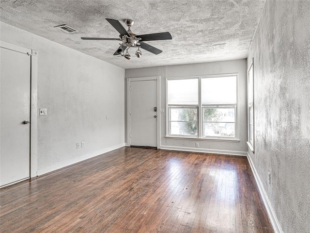 empty room with ceiling fan and dark hardwood / wood-style floors