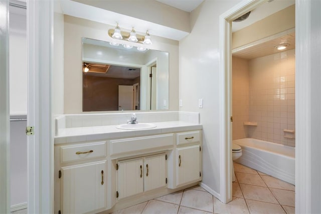 full bathroom featuring toilet, tile patterned flooring, tiled shower / bath, and vanity