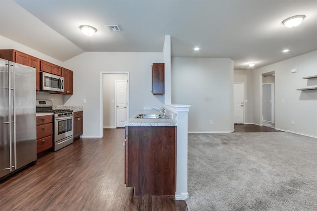 kitchen with lofted ceiling, dark carpet, sink, and stainless steel appliances