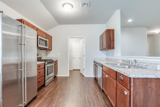 kitchen with sink, appliances with stainless steel finishes, dark hardwood / wood-style flooring, and lofted ceiling