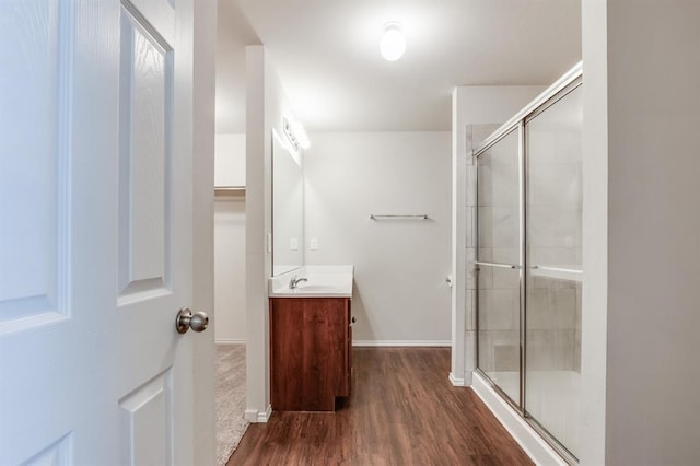 bathroom with walk in shower, vanity, and hardwood / wood-style flooring