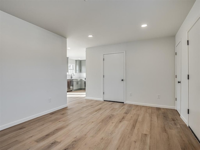 empty room with light hardwood / wood-style floors and sink