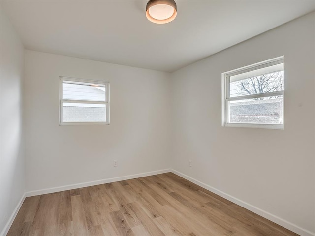 spare room with plenty of natural light and light hardwood / wood-style flooring