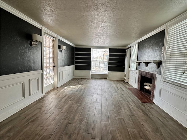 unfurnished living room with a textured ceiling, a healthy amount of sunlight, a brick fireplace, and built in shelves