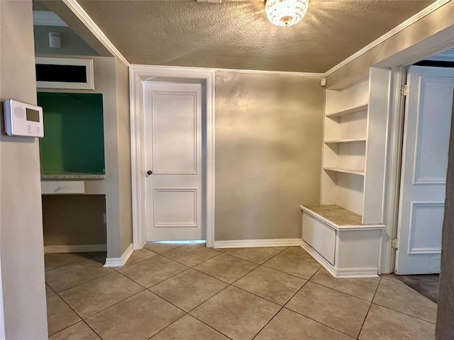 mudroom featuring built in shelves, a textured ceiling, and tile patterned floors