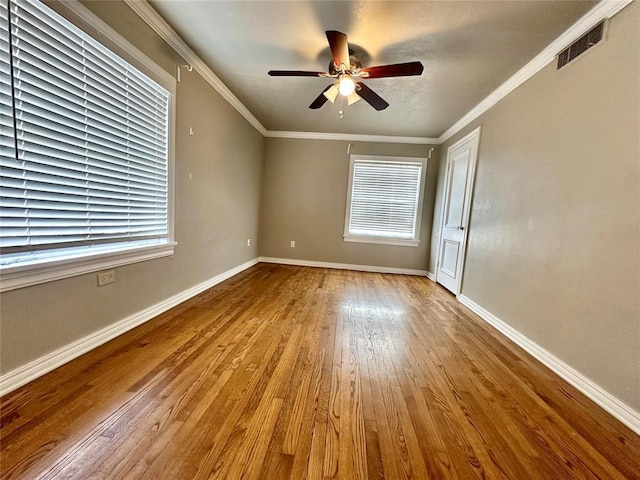 empty room with ornamental molding, ceiling fan, a healthy amount of sunlight, and light wood-type flooring