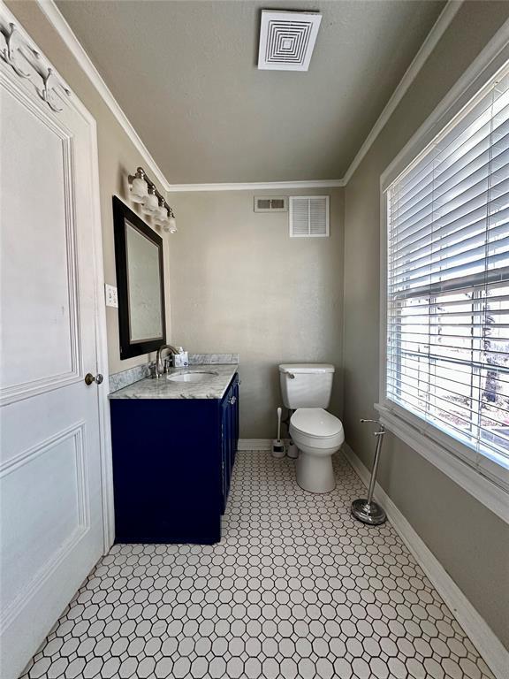 bathroom featuring toilet, crown molding, tile patterned floors, and vanity