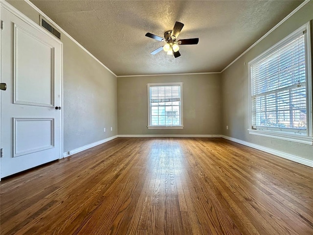 empty room with hardwood / wood-style flooring, a textured ceiling, ceiling fan, and ornamental molding