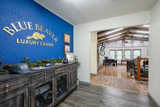 bar featuring ceiling fan, a textured ceiling, dark hardwood / wood-style floors, and lofted ceiling with beams