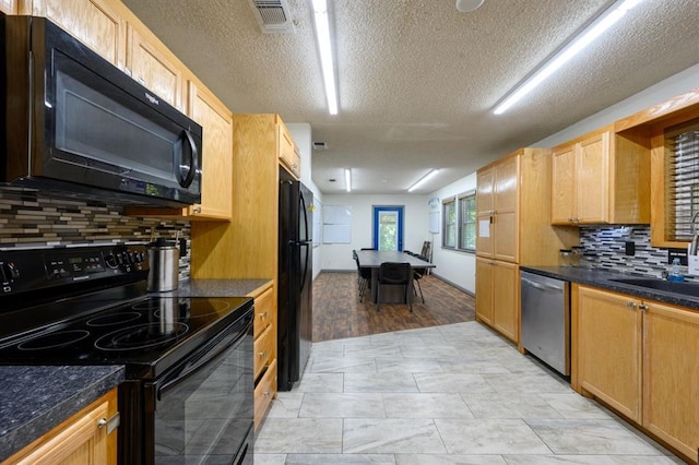 kitchen with black appliances, decorative backsplash, and sink