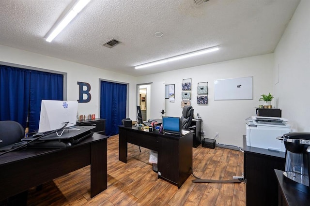 home office featuring wood-type flooring and a textured ceiling