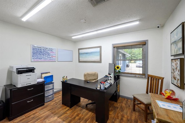 home office with a textured ceiling and dark hardwood / wood-style flooring