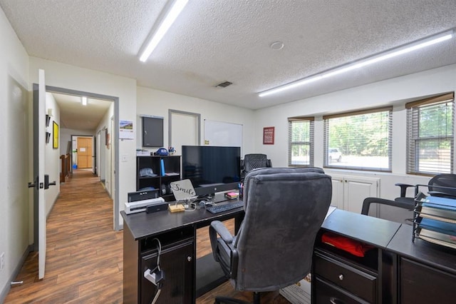 home office featuring dark wood-type flooring and a textured ceiling