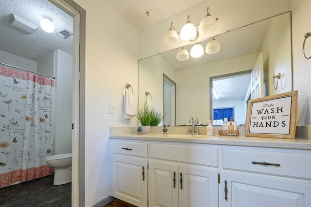 bathroom with toilet, vanity, a shower with curtain, and a textured ceiling