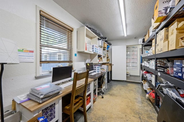 home office featuring a textured ceiling and concrete flooring