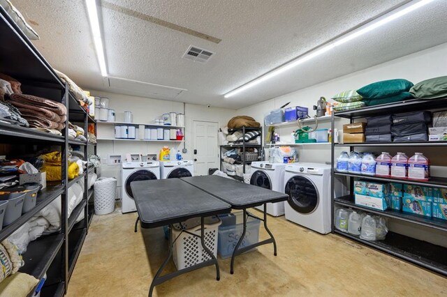 clothes washing area with a textured ceiling and washing machine and dryer