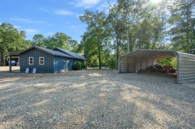 view of side of home with a carport and an outdoor structure