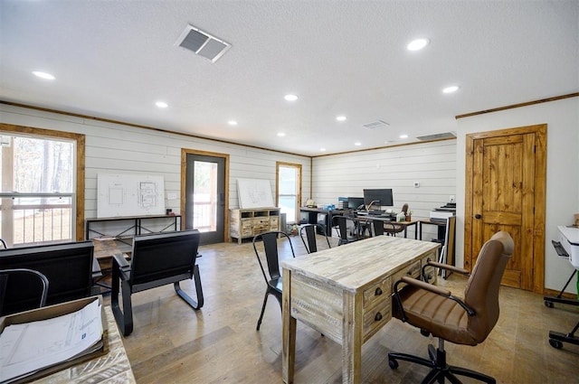 office featuring a textured ceiling, ornamental molding, light hardwood / wood-style floors, and wood walls