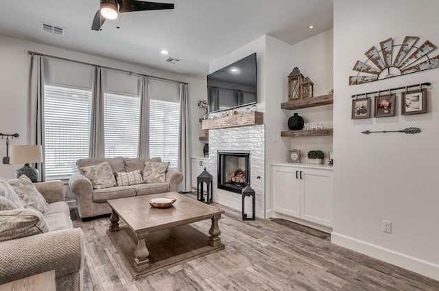 living room featuring ceiling fan and light hardwood / wood-style flooring