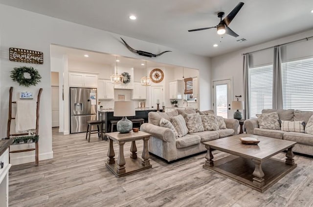 living room with ceiling fan and light wood-type flooring