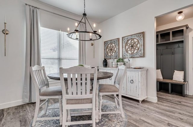 dining room with light wood-type flooring and an inviting chandelier