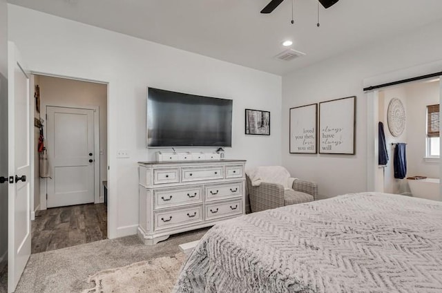 bedroom featuring carpet, ceiling fan, a barn door, and connected bathroom